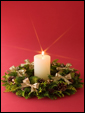 В вечнозеленом папоротниковом венке горит рождественская свеча: Счастливого Рождества