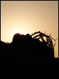 Образ распятого Иисуса Христа, лежащего на фоне аходящего солнца.