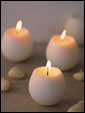 Три круглых свечи издают романтический нежный свет, создавая романтическую атмосфера праздника.