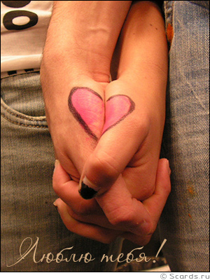Парень и девушка, взявшись за руки, образовали изображение сердечка, символизирующего любовь.