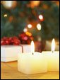 Горящие свечи на фоне новогодней елки с наилучшими пожеланиями получателю.