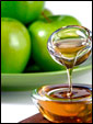 Густой, ароматный мед стекает с ложки на фоне сочных сладких яблок: сладкого тебе Нового Года.