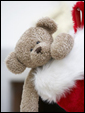 Маленький плюшевый мишка, выглядывая из новогоднего мешочка говорит о том, что он ждет встречи с получателем.
