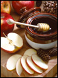 На праздничном столе стоят традиционные угощения: яблоки, мед. С Новым Годом!